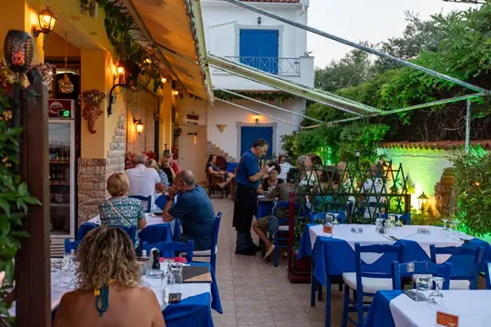 The side street beside the taverna, tables out under the vines